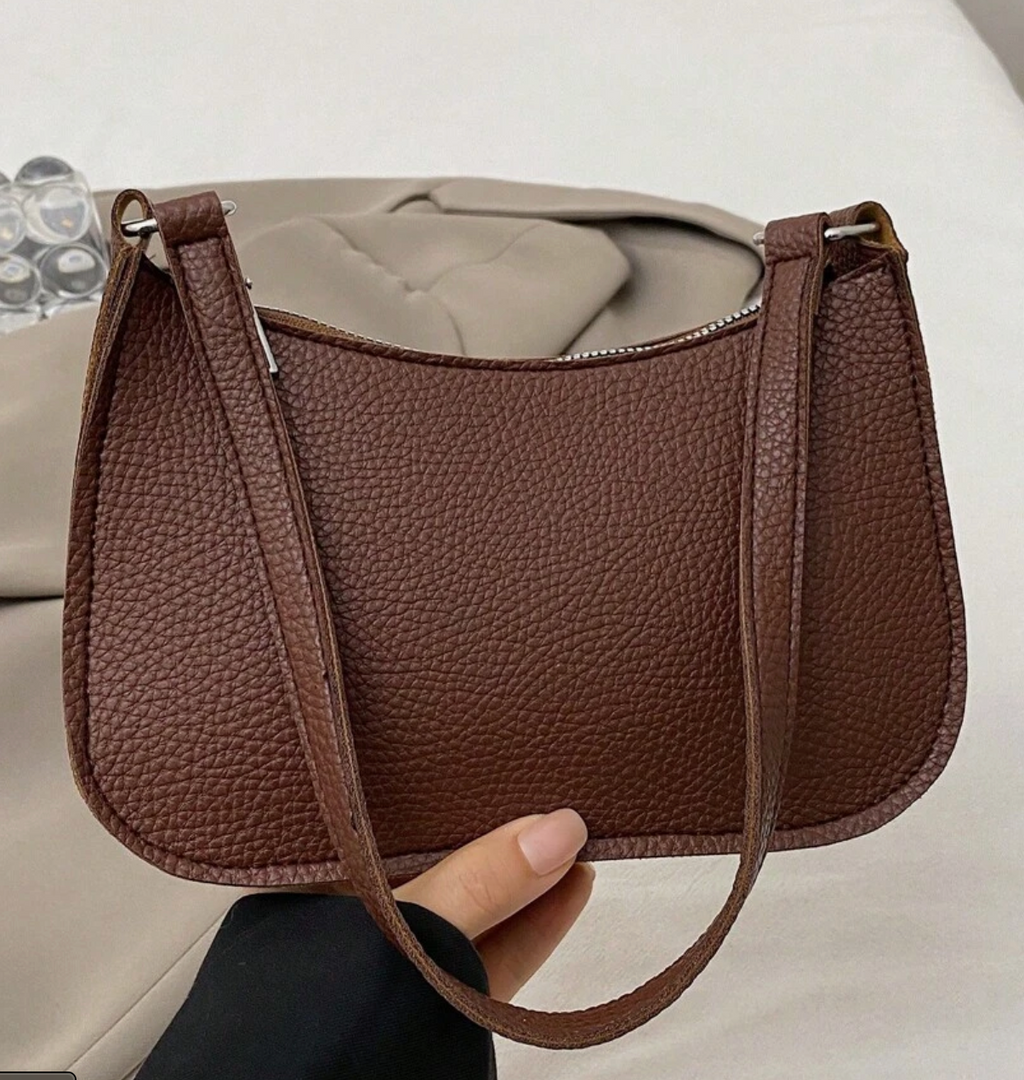 Lyana Rouge bag in brown held by a hand