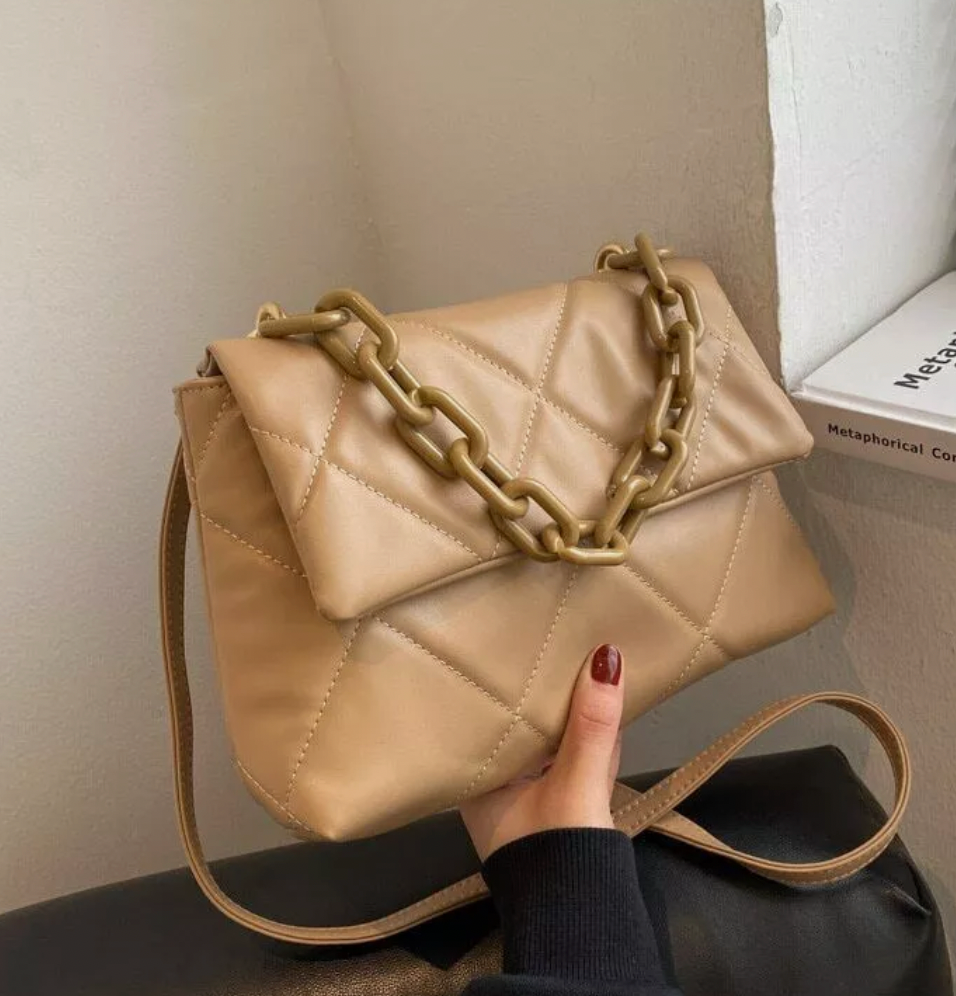 Fluffy quilted brown handbag with chunky chain detail and long strap, stylish and spacious accessory for any occasion.