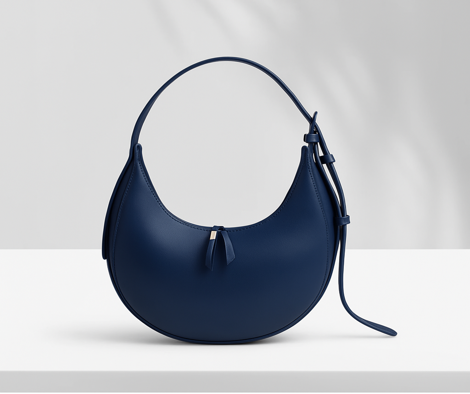 Sleek Lyana Claudia black hobo bag with U-shaped design, single zipper compartment, and adjustable shoulder strap.
